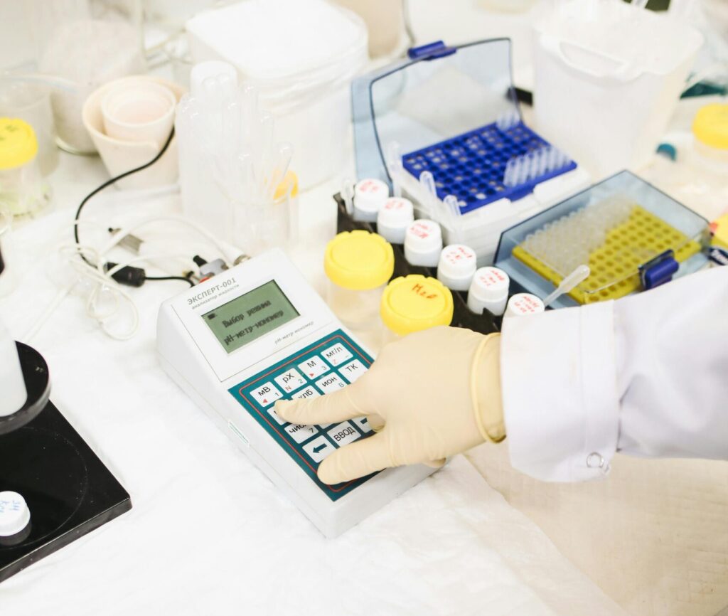 Scientist interacts with a device amidst laboratory equipment for research purposes.